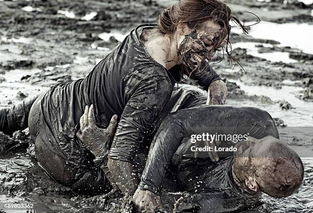 young couple wrestling during a mud run - women wrestling stock pictures, royalty-free photos & images