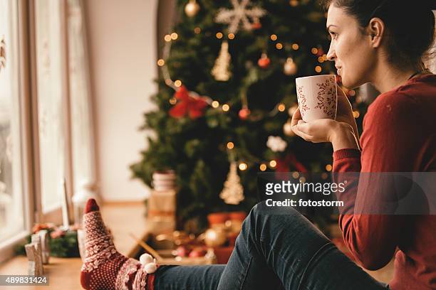 giovane donna bere tè con l'albero di natale - hot chocolate foto e immagini stock
