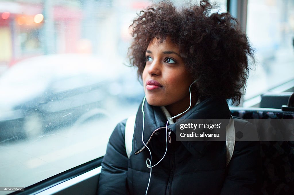 Young girl listening to music on public transport