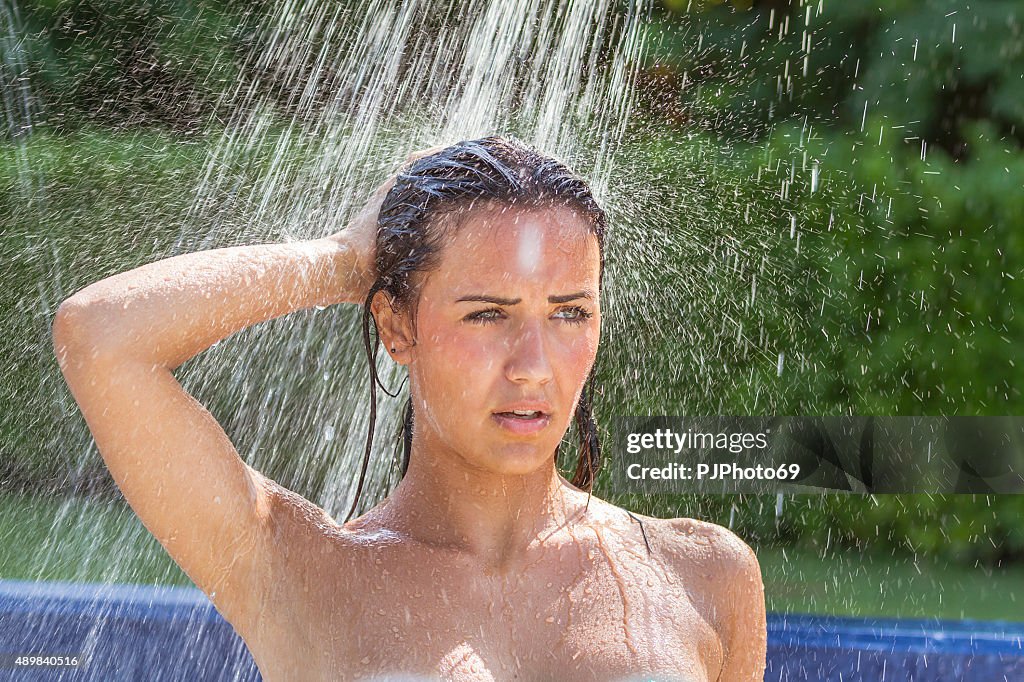 Jeune femme sous la douche en plein air