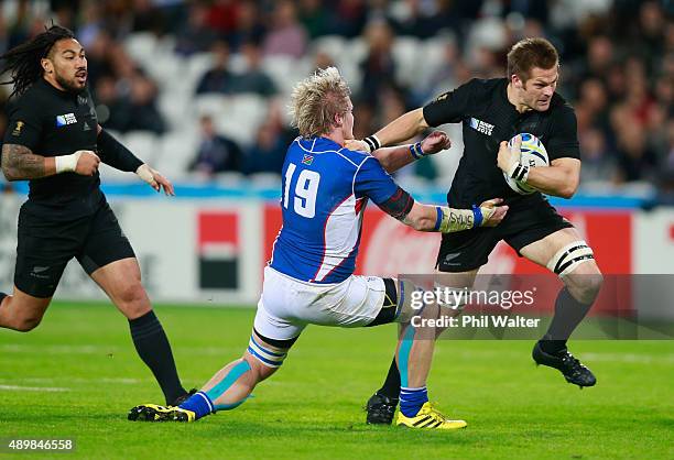 Richie McCaw of the New Zealand All Blacks is tackled by Renaldo Bothma of Namibia during the 2015 Rugby World Cup Pool C match between New Zealand...