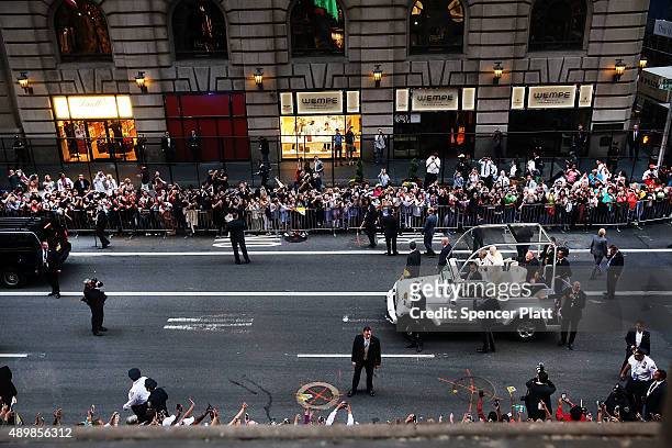 From a window st the St. Regis Hotel, Pope Francis is viewed as he makes his way down 5th Avenue towards St. Patricks Cathedral on September 24, 2015...