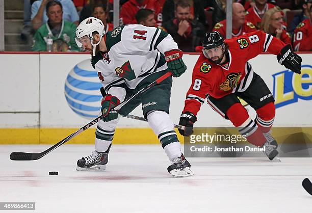 Justin Fontaine of the Minnesota Wild controls the puck under pressure from Nick Leddy of the Chicago Blackhawks in Game Five of the Second Round of...