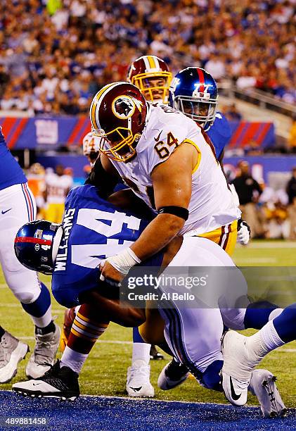 Andre Williams of the New York Giants scores a first quarter touchdown as Kedric Golston of the Washington Redskins defends at MetLife Stadium on...