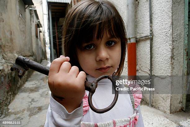 The granddaughter of Palestinian refugee, Subhia Abdul Rahim Abu Ghali, 79 years old, from the Rafah refugee camp holds up a key allegedly from her...