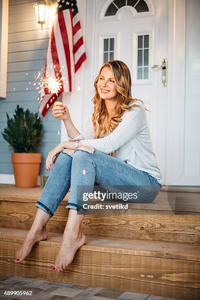 woman in front of a house. - american flag fireworks stock pictures, royalty-free photos & images
