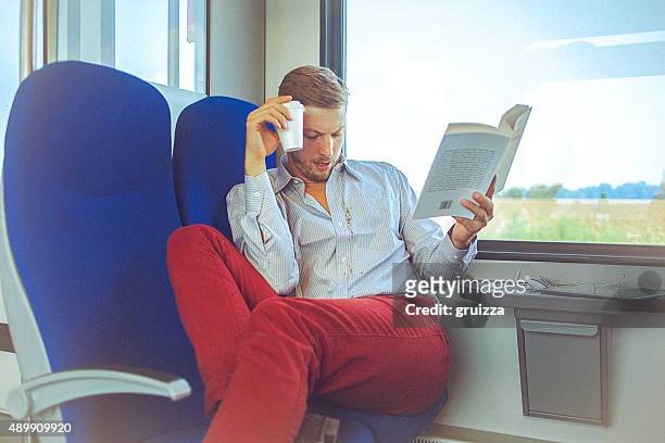 young handsome man in train spilling coffee on shirt - stained shirt stock pictures, royalty-free photos & images