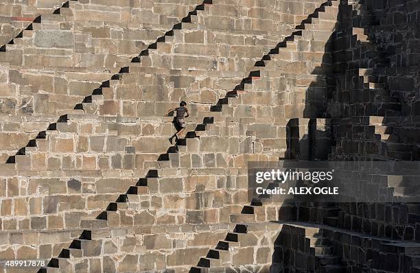 An Indian boys walks up the steps of the historic Chand Baori stepwell in Abhaneri village in Rajasthan on September 24, 2015. For a few hours on one...