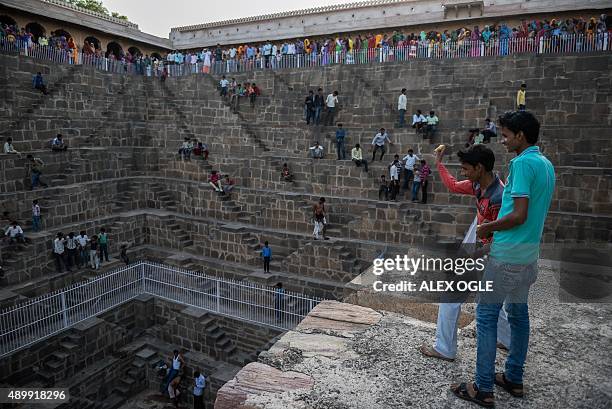 Indian youths throw fruit at their friends in the historic Chand Baori stepwell in Abhaneri village in Rajasthan on September 24, 2015. For a few...