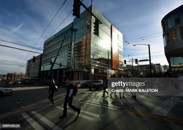 People walk past part of the new Amazon headquarter complex under construction in downtown Seattle, Washington on September 24, 2015. Amazon's new...