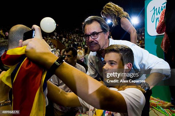 Leader of Catalan Democratic Convergence 'Convergencia Democratica de Catalunya' party Artur Mas takes a selfie with a young supporter during a...