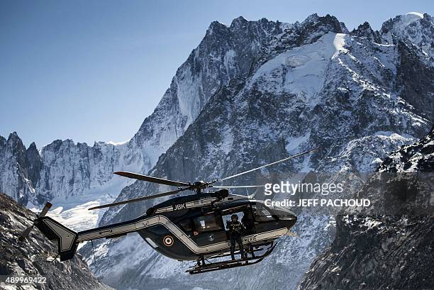 Gendarmerie helicopter flies across the Mont Blanc mountains during a mountain rescue exercise on September 25, 2015 near Chamonix, France. AFP PHOTO...