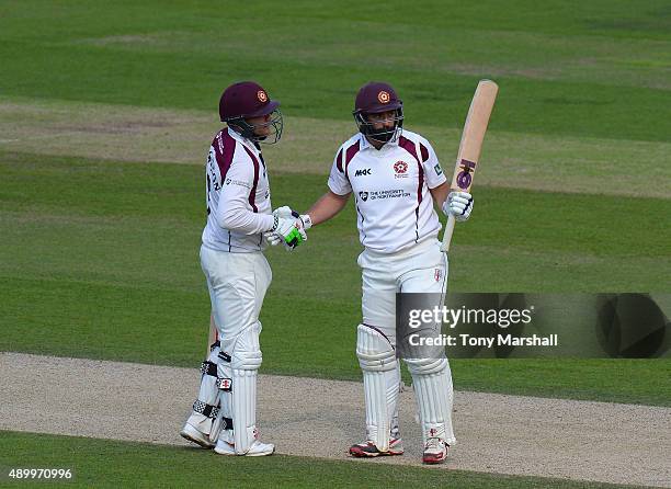 David Murphy of Northamptonshire celebrates reaching his 50 with Adam Rossington during the LV County Championship - Division Two match between...