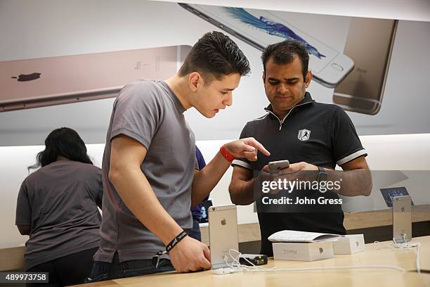 Apple store employee Cristian Zuniga shows the new iPhone 6s to Rajeev Sharma On September 25, 2015 in Chicago, Illinois. Apple launched the new...