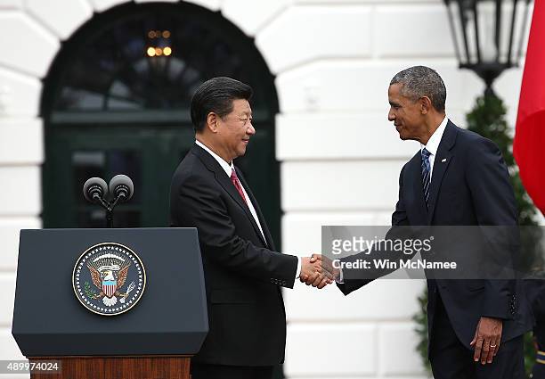 President Barack Obama shakes hands with Chinese President Xi Jinping during a state arrival ceremony on the south lawn of the White House grounds...