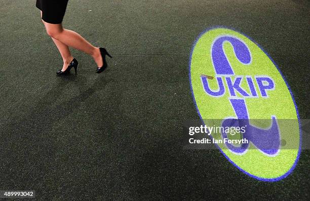 Woman walks past a UK Independence Party logo projected onto a carpet during the UK Independence Party annual conference at Doncaster Racecourse on...