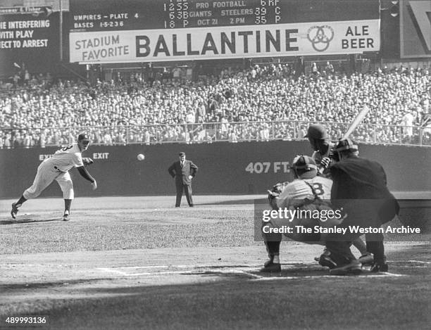 Pitcher Don Larson of the New York Yankees delivers the first pitch to Jim Gilliam of the Brooklyn Dodgers as catcher Yogi Berra and umpire Babe...