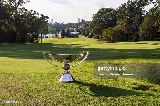 The FedExCup trophy is arranged for a photo on the 15th hole green with a view of the Atlanta skyline during practice for the TOUR Championship by...