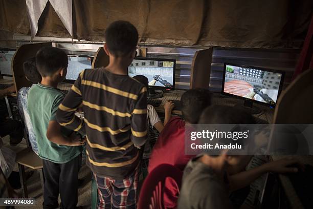 Syrian refugee boys play war games on computers at an internet cafe at a tent city in the Akcakale District of Sanliurfa, Turkey on September 24,...
