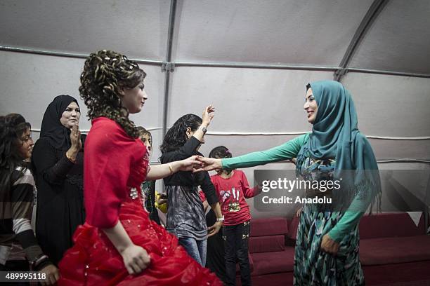 Havazi Hilen a refugee girl who fled Syria three months ago with her family, dances with her relatives during her henna night at a tent city in the...