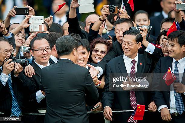 Xi Jinping, China's president, greets attendees during a ceremony with U.S. President Barack Obama, not pictured, on the South Lawn of the White...