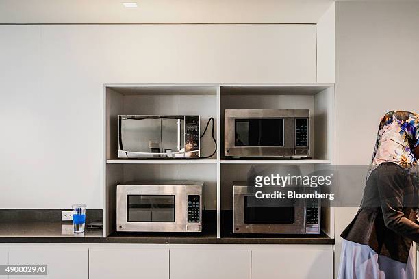 An employee walks past microwaves during lunch in the cafeteria of the New York Stock Exchange in New York, U.S., on on Wednesday, Aug. 26, 2015....