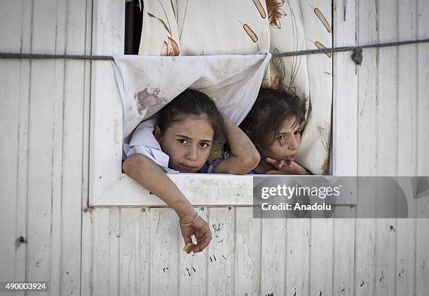 Syrian refugee girls are seen on the window of their prefabricated house at a tent city in the Akcakale District of Sanliurfa, Turkey on September...
