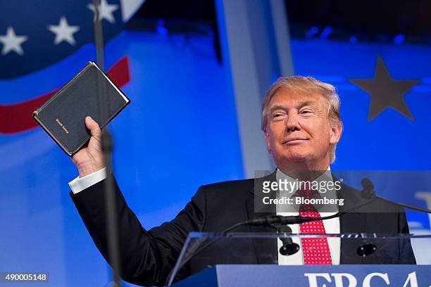 Donald Trump, president and chief executive of Trump Organization Inc. And 2016 Republican presidential candidate, holds up a Bible while speaking at...