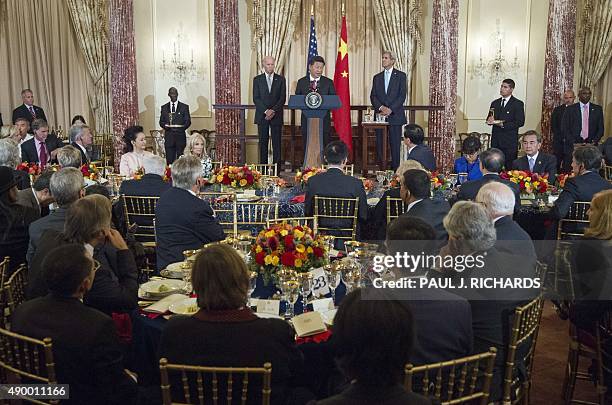 Chinese President Xi Jinping speaks as US Vice President Joe Biden and US Secretary of State John Kerry listen during a State luncheon in honor of...