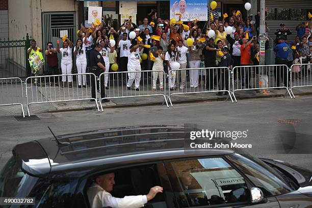 People cheer as Pope Francis arrives in his Fiat to the Lady Queen of Angels school on September 25, 2015 in New York City. The Pope visited the...