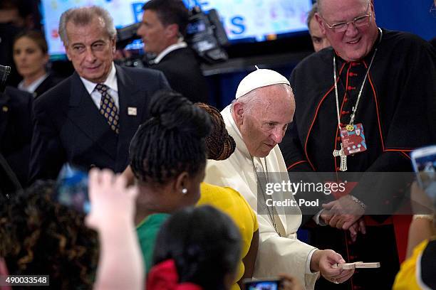 Pope Francis hands a cross to a child at Our Lady Queen of Angels on September 25, 2015 in the neighborhood of East Harlem in New York City. Pope...