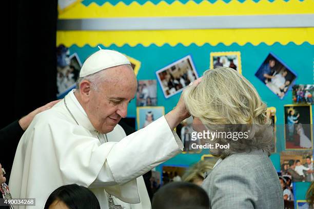 Pope Francis blesses Laurie Grauer during a visit to Our Lady Queen of Angels School September 21, 2015 in the East Harlem neighborhood of New York...