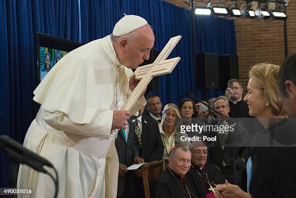 Pope Francis kisses a cross presented to him as a gift inside Our Lady Queen of Angels School September 25, 2015 in the East Harlem neighborhood of...