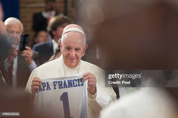 Pope Francis receives a gift shirt inside Our Lady Queen of Angels School September 25, 2015 in the East Harlem neighborhood of New York City. Pope...