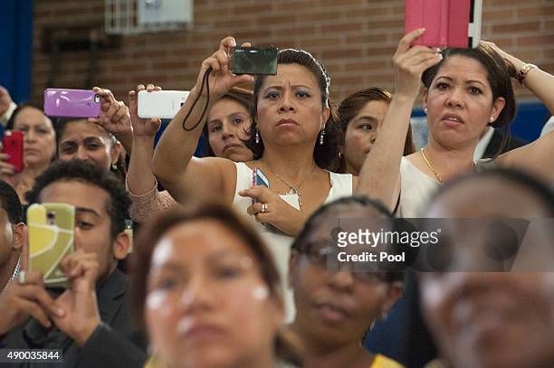 Audience members take video and photos as Pope Francis greets people inside Our Lady Queen of Angels School September 25, 2015 in the East Harlem...