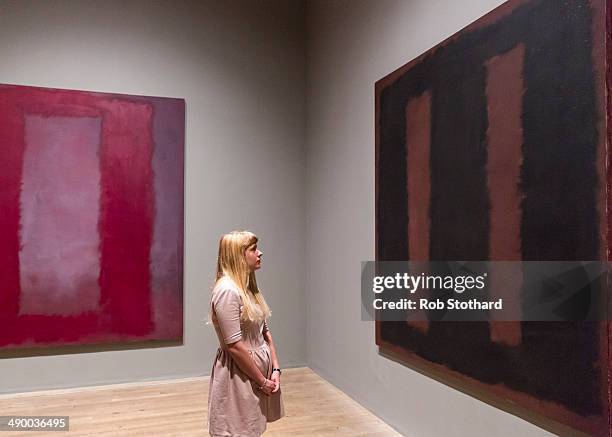 Woman poses with Mark Rothko's painting Black On Maroon 1958 after going back on display at Tate Modern gallery, 18 months after it was vandalised...