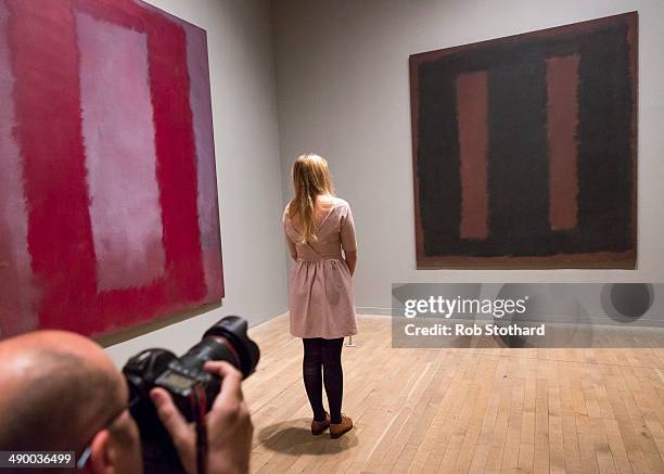 Woman poses with Mark Rothko's painting Black On Maroon 1958 after going back on display at Tate Modern gallery, 18 months after it was vandalised...