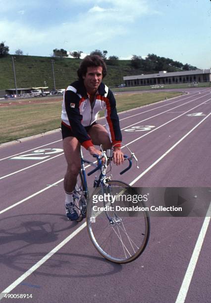 Actor Tom Wopat rides a bicycle wearing a Fila running jacket and New Balance sneakers in 1980 in Los Angeles, California.
