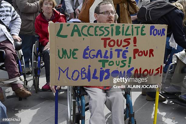 Disabled man holds a placard reading "Accessibility for all! Equality for all! Let's mobilise!" as he takes part in a demonstration called by the...