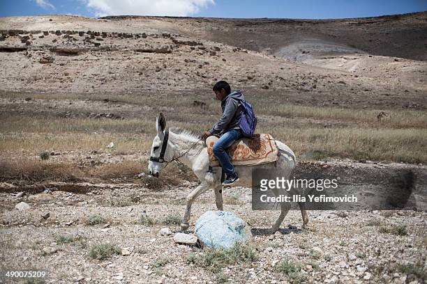 Pupil rides a donkey after a day of lessons at a Palestinian Bedouin of Jahaline tribe school in the area of E1, not far from the settlement of Maale...