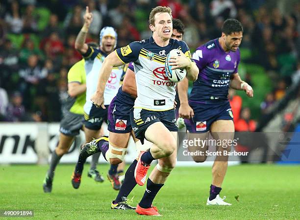 Michael Morgan of the Cowboys runs away to score a try as Johnathan Thurston of the Cowboys celebrates during the NRL Second Preliminary Final match...