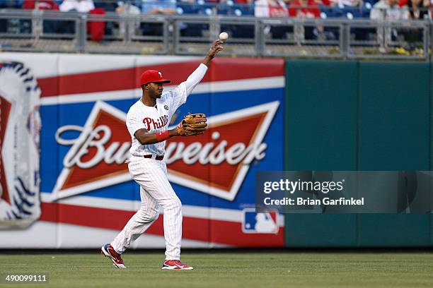 Domonic Brown of the Philadelphia Phillies throws the ball infield during the game against the Miami Marlins at Citizens Bank Park on April 12, 2014...