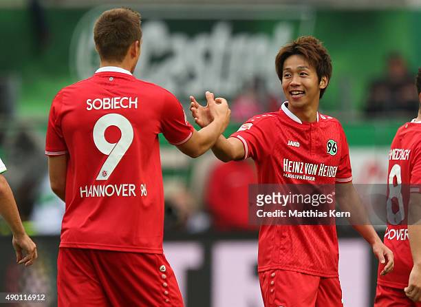 Hiroshi Kiyotake of Hannover jubilates with team mate Artur Sobiech after scoring the second goal during the Bundesliga match between VFL Wolfsburg...