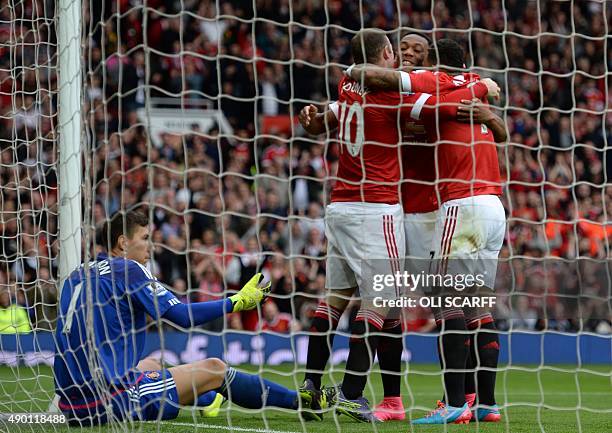 Manchester United's English striker Wayne Rooney celebrates with teammates after scoring their second goal during the English Premier League football...