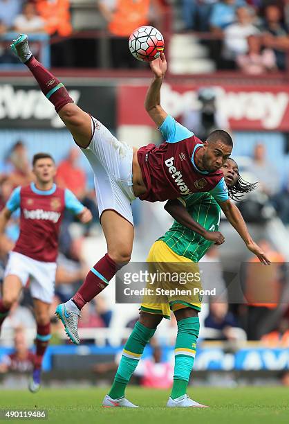 Winston Reid of West Ham United and Dieumerci Mbokani of Norwich City compete for the ball during the Barclays Premier League match between West Ham...