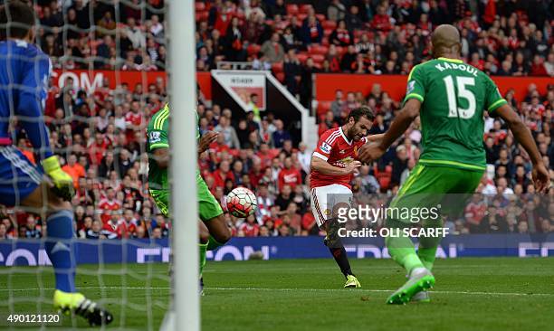 Manchester United's Spanish midfielder Juan Mata shoots the score their third goal past Sunderland's Romanian goalkeeper Costel Pantilimon during the...