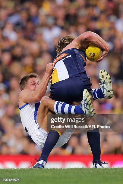 Matt Priddis of the Eagles is tackled by Andrew Swallow of the Kangaroos during the AFL Second Preliminary Final match between the West Coast Eagles...