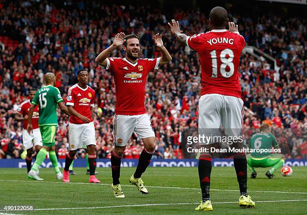 Juan Mata of Manchester United celebrates scoring his team's third goal with his team mate Ashley Young during the Barclays Premier League match...