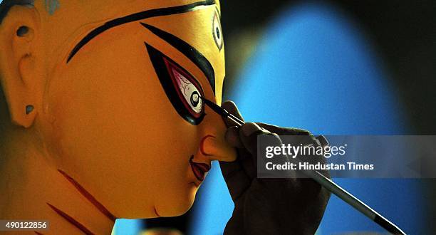 An artisan making idol of Goddess Durga for the Durga Puja celebrations at Kumartuli, on September 26, 2015 in Kolkata, India. Durga Puja festival...