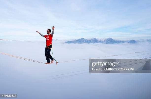 France's Guillaume Rolland walks on the line during the Highline Extreme event in Moleson peak, western Switzerland on September 26, 2015. Fifty of...